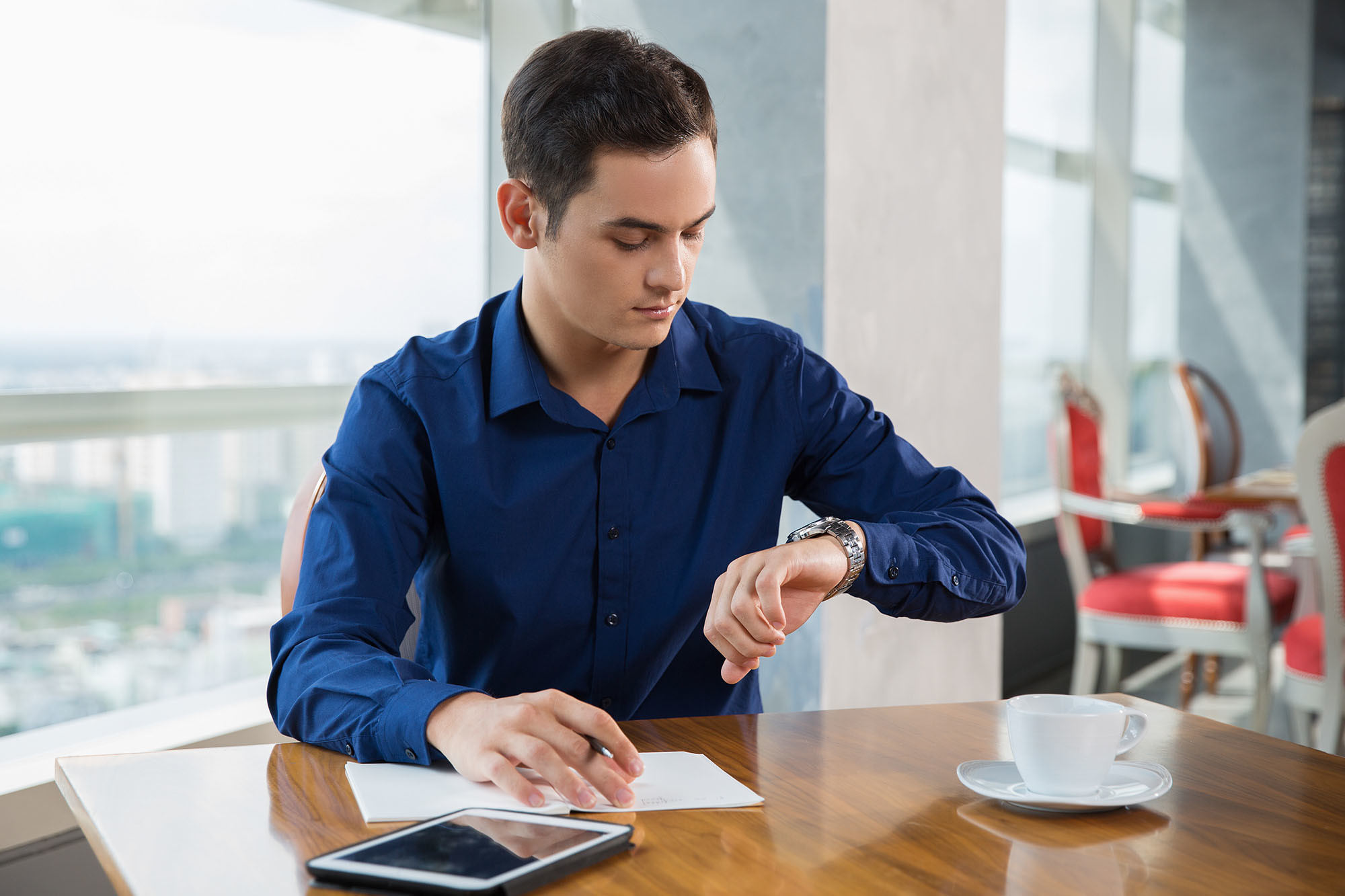 Serious Young Businessman Looking at Wrist Watch Time Management